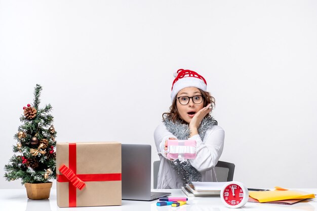 Vooraanzicht vrouwelijke werknemer die voor haar werkplek zit met een klein aanwezig vrouwwerk kerstbaantje