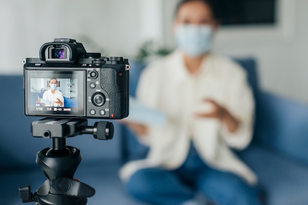 Gratis foto vooraanzicht wazige vrouw naar huis streaming terwijl het dragen van een gezichtsmasker