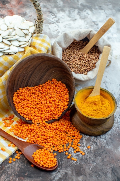 Gratis foto vooraanzicht witte zaden met oranje linzen en peper op lichte ondergrond