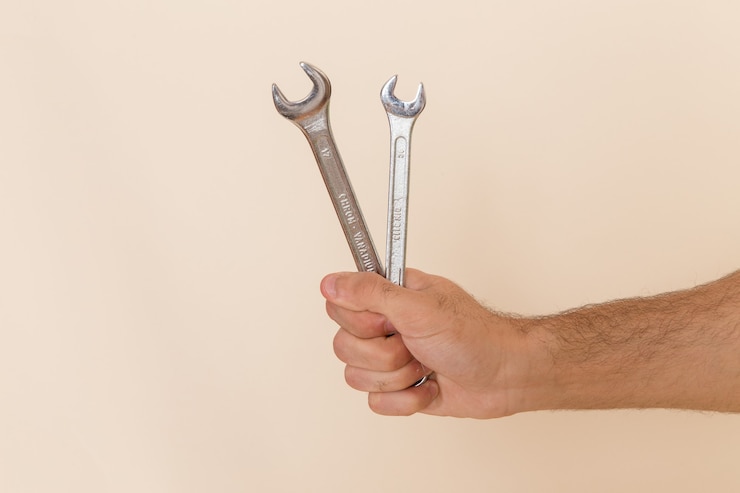 Gratis Foto vooraanzicht zilveren gereedschap vastgehouden door mannetje op licht bureau instrument gereedschap mannetje