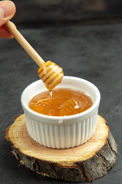 Vooraanzicht zoete honing op de donkere achtergrond ei ontbijt kleur voedsel maaltijd brood Premium Foto
