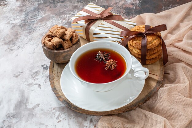 Vooraanzicht zoete koekjes met heden en kopje thee op lichte achtergrondkleur taart thee cookie zoete gebak cake suiker