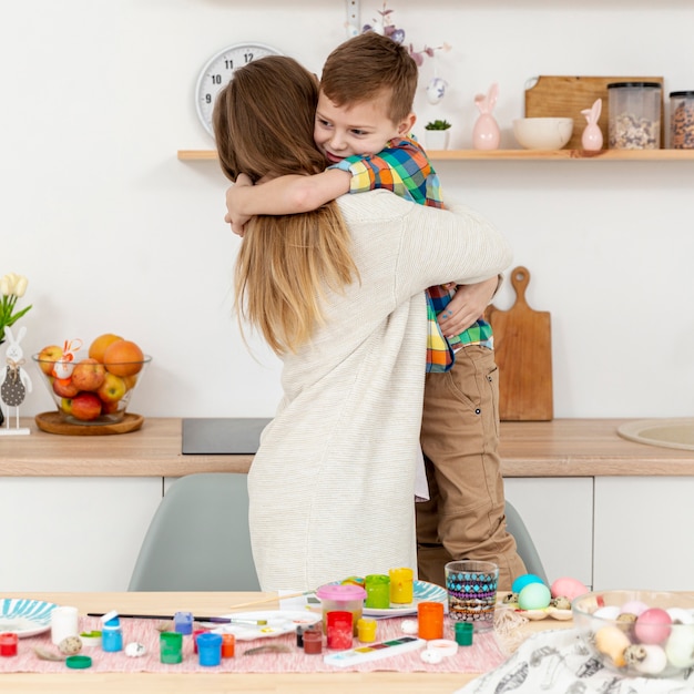 Gratis foto vooraanzicht zoon knuffelen zijn moeder