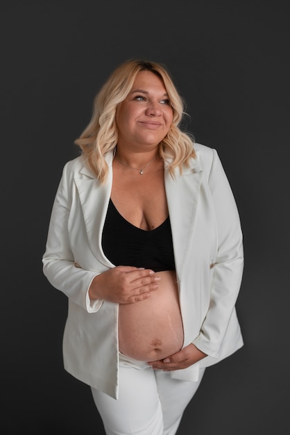 Gratis foto vooraanzicht zwangere vrouw poseren in studio