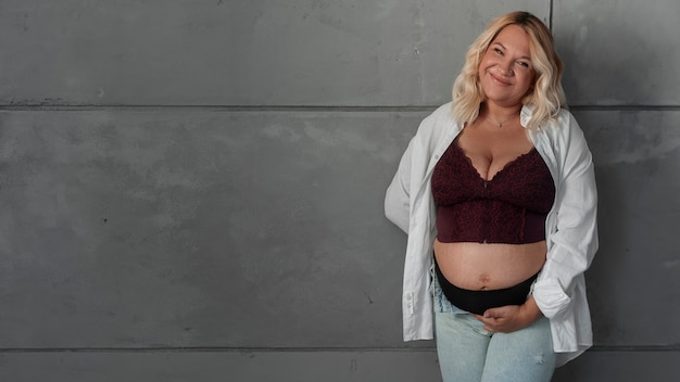 Gratis foto vooraanzicht zwangere vrouw poseren in studio