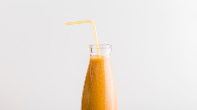 Gratis foto vooraanzichtfles met oranje smoothie en stro