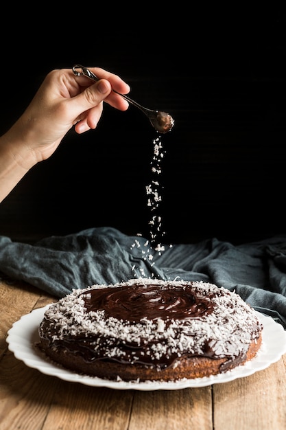 Vooraanzichthand die chocoladecake verfraaien