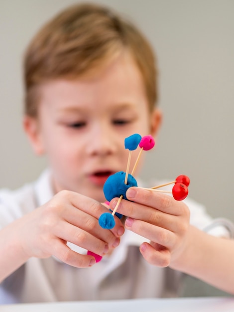 Vooraanzichtjongen het spelen met kleurrijk atoomspel