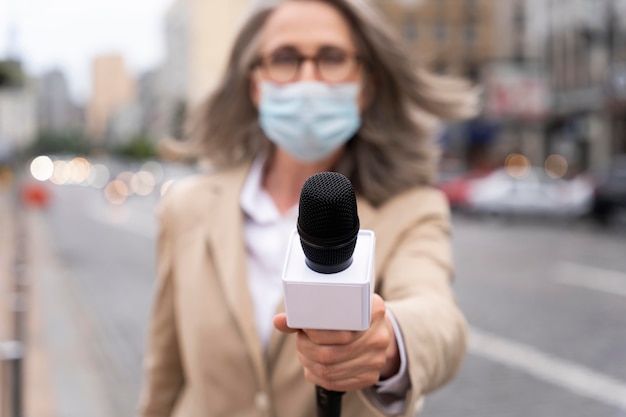 Vooraanzichtjournalist die een microfoon vasthoudt