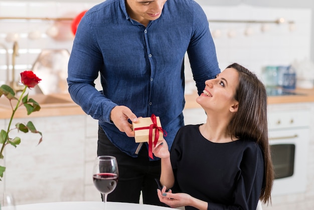 Vooraanzichtman die zijn vrouw een aanwezige Valentijnsdag geeft