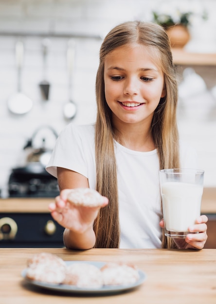 Vooraanzichtmeisje dat een koekje neemt