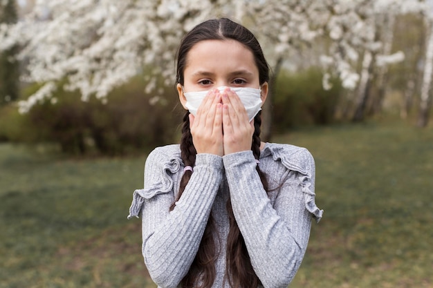 Gratis foto vooraanzichtmeisje met masker in openlucht