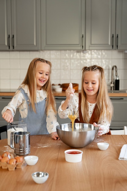 Gratis foto vooraanzichtmeisjes die in keuken koken