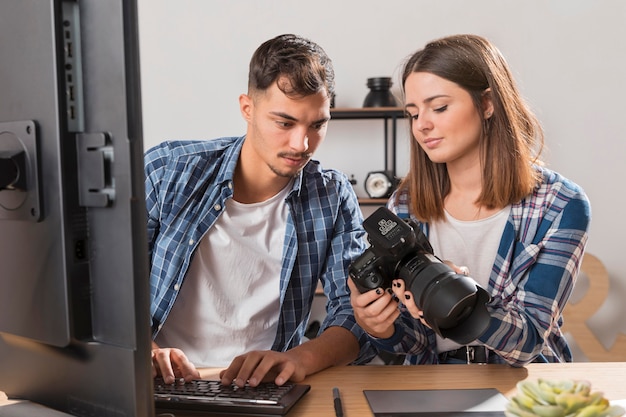 Gratis foto vooraanzichtmensen die samen foto's op camera bekijken