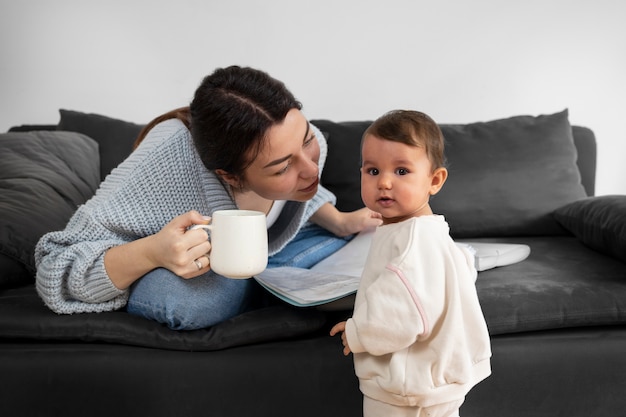 Vooraanzichtmoeder met baby thuis