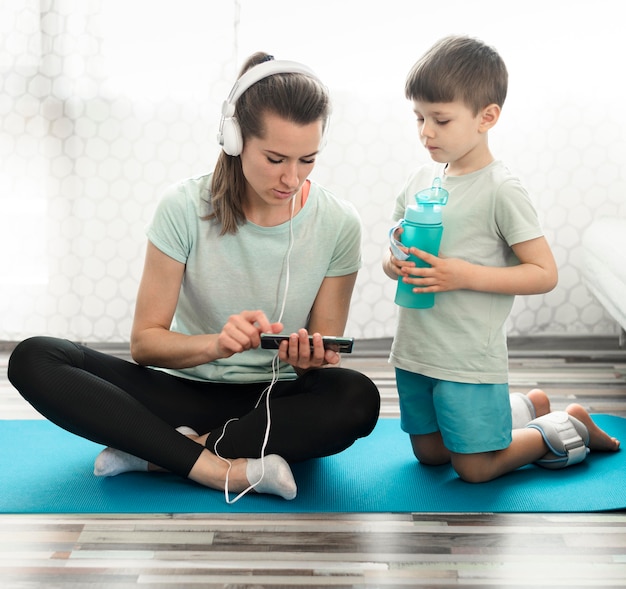 Gratis foto vooraanzichtmoeder samen met zoon op yogamat