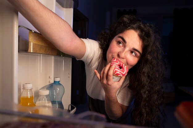 Vooraanzichtvrouw die donut eet