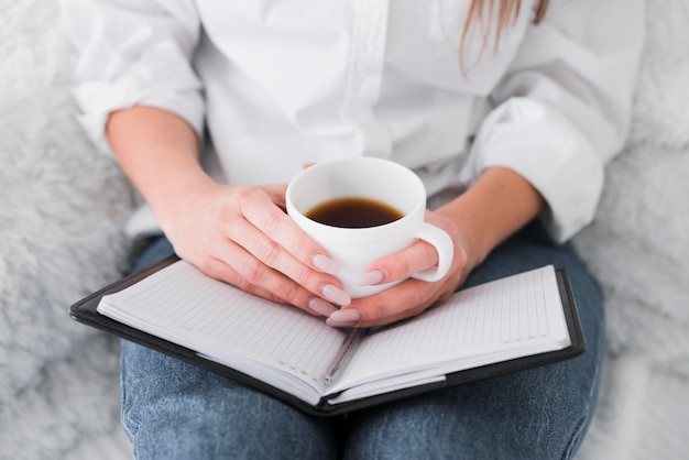 Vooraanzichtvrouw die een kop van koffie houdt