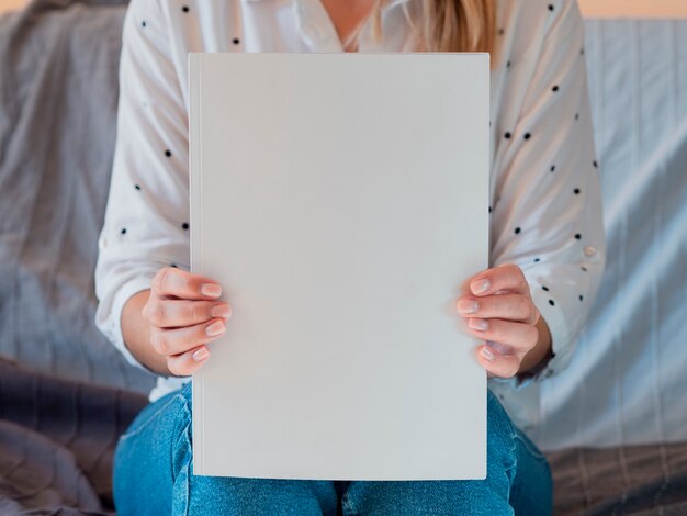 Vooraanzichtvrouw die een modeltijdschrift houdt