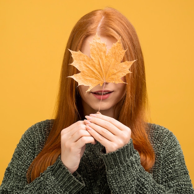 Gratis foto vooraanzichtvrouw die geel blad houdt