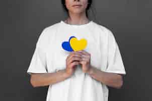 Gratis foto vooraanzichtvrouw die gele en blauwe harten houdt