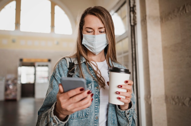 Vooraanzichtvrouw die medisch masker draagt bij treinstation