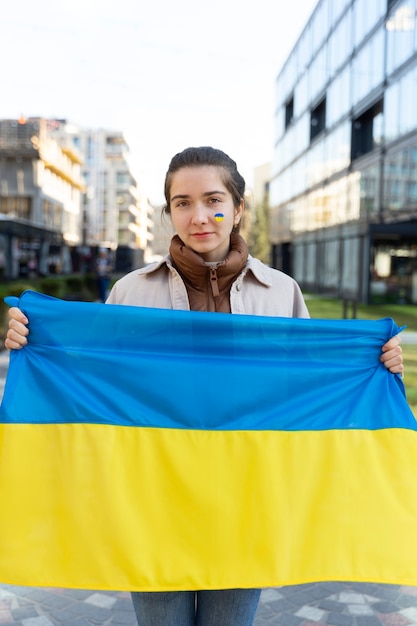 Gratis foto vooraanzichtvrouw die oekraïense vlag houdt