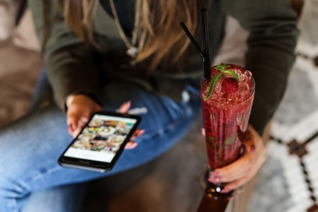 Vooraanzichtvrouw het drinken aardbeicocktail met zwart stro