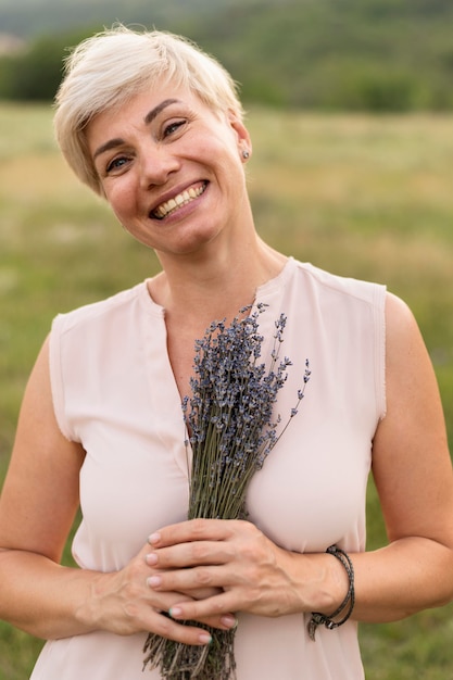 Vooraanzichtvrouw het stellen met bloemen