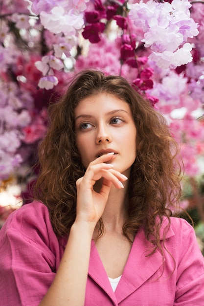 Gratis foto vooraanzichtvrouw het stellen met bloemen