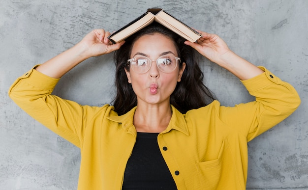 Gratis foto vooraanzichtvrouw met boek en glazen