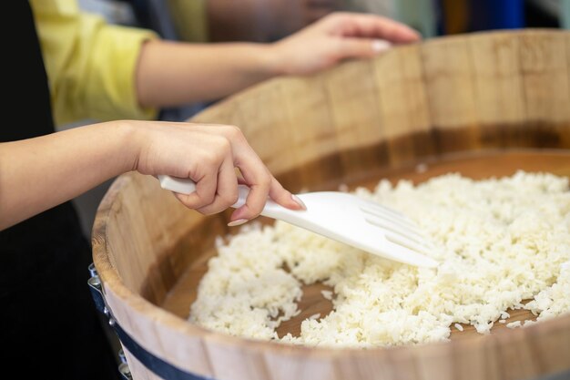 Voorbereiding. Vrouw die rijst klaarmaakt voor sushi in de keuken van het restaurant