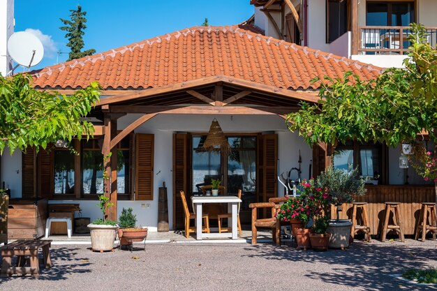 Voortuin en terras van een restaurant in nationale stijl met groen, stoelen en tafels in Nikiti, Griekenland