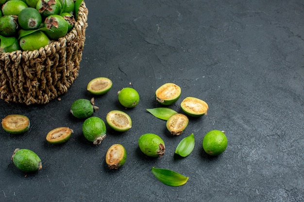 Voorzijde halve verse feijoas in mand op donkere ondergrond