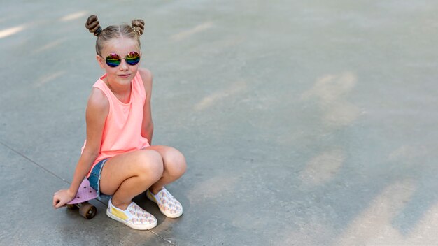 Voorzijde vie van meisjeszitting op skateboard