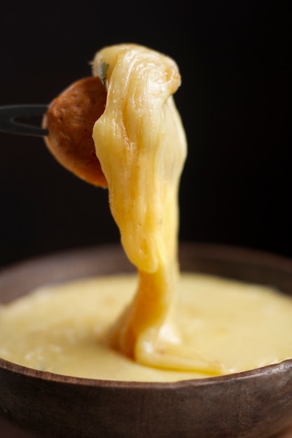 Vork met champignon gedoopt in gesmolten kaas