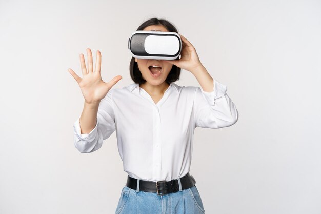 Vr chat Aziatisch meisje zegt hallo in virtual reality-bril glimlachend enthousiast concept van communicatie en toekomstige technologie witte achtergrond