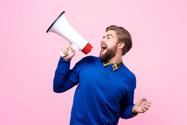 Vreugdevolle man schreeuwt in de megafoon