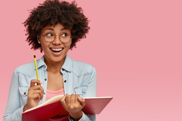 Vreugdevolle zwarte schrijver werkt aan een nieuw boek voor lezers.
