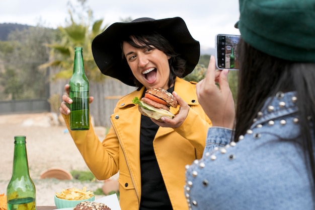 Vriend die foto's maakt van vrouw met hamburger