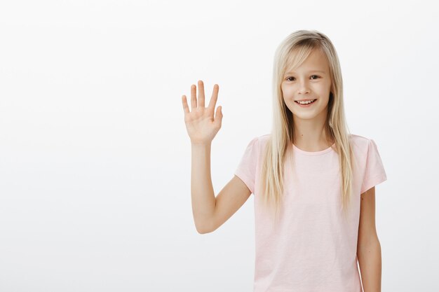 Vriendelijk lachende jongen hallo zeggen, kleine vrouw zwaaiende hand zeg hallo