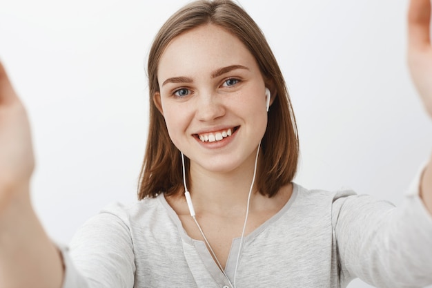 Vriendelijk ogende schattig en gelukkig jonge vrouw selfie te nemen