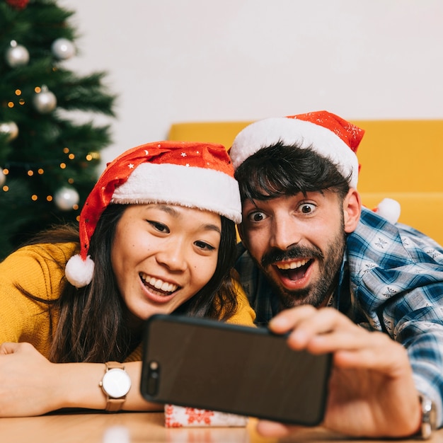 Vriendelijk paar dat selfie bij Kerstmis neemt