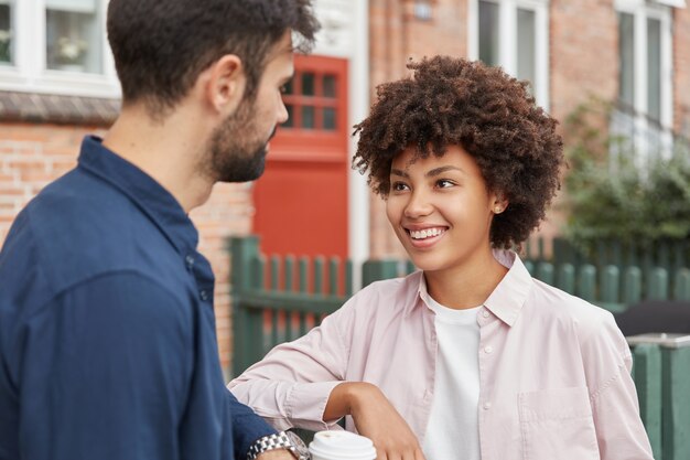 Vriendelijke, beste vrienden van gemengd ras genieten van een gesprek met elkaar