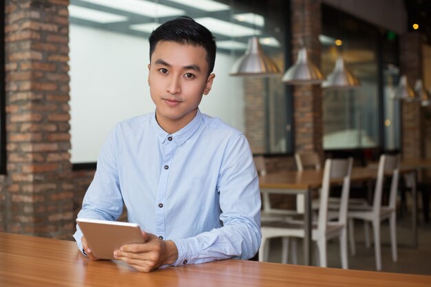 Vriendelijke man zitten bij Cafe Tafel met Tablet