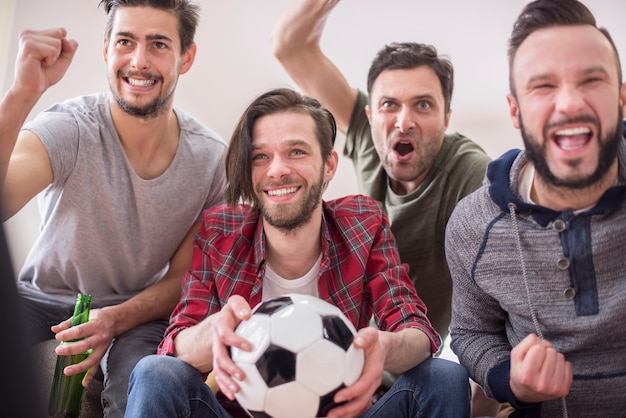 Vrienden bier drinken en voetbalwedstrijd kijken