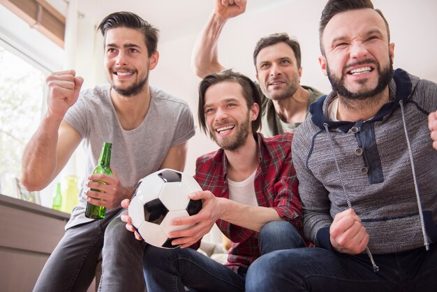 Vrienden bier drinken en voetbalwedstrijd kijken