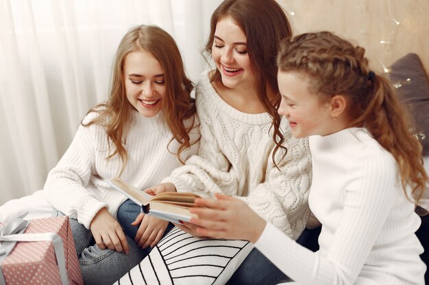 Vrienden brachten tijd thuis door. Vrouwen met cadeau. Zusters met een boek.