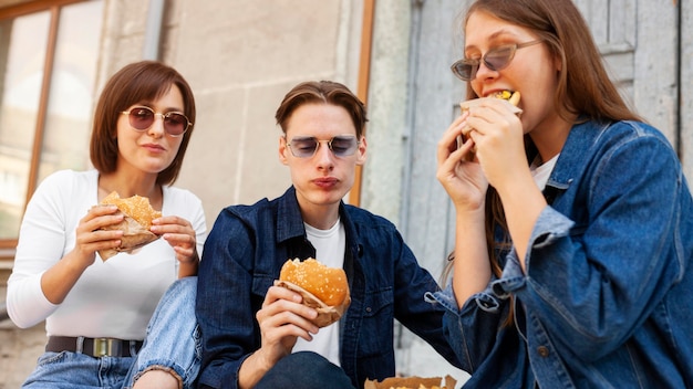 Vrienden buiten eten van hamburgers