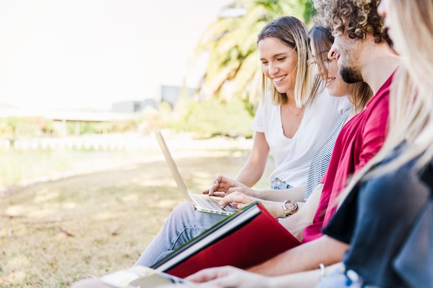 Vrienden die buiten met laptop bestuderen